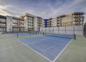 Thumbnail 5 of 26 - a tennis court with apartments in the background