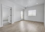 Thumbnail 22 of 26 - an empty living room with white walls and wood floors