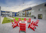 Thumbnail 17 of 26 - an outdoor patio with red chairs and a fire pit