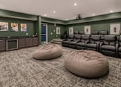 Thumbnail 17 of 35 - A room with a row of black leather chairs and two bean bag chairs in front of them.