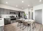 Thumbnail 22 of 26 - A modern kitchen with a dining table set for two.