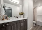 Thumbnail 18 of 26 - A bathroom with a white countertop and a mirror above it.