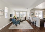 Thumbnail 14 of 23 - an open living room and kitchen with a bar and a living room with couches