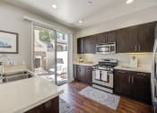 Thumbnail 12 of 23 - a kitchen with a sink and stove and a door to a patio