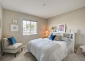 Thumbnail 18 of 23 - a bedroom with a bed and a chair and a window