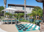 Thumbnail 10 of 23 - an outdoor checkers game with a table and chairs