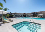 Thumbnail 7 of 23 - a swimming pool and spa with chairs and umbrellas