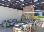 Thumbnail 11 of 23 - a patio with a fireplace and chairs and tables