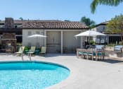 Thumbnail 8 of 23 - a swimming pool in front of a house with tables and umbrellas