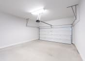 Thumbnail 24 of 31 - a garage with a white wall and a white garage door