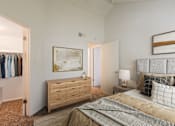 Thumbnail 49 of 51 - A bedroom with a bed, nightstand, and a painting on the wall.