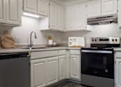 Thumbnail 47 of 51 - A kitchen with white cabinets and a black oven.