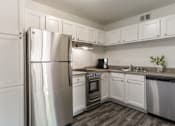 Thumbnail 11 of 51 - an empty kitchen with stainless steel appliances and white cabinets