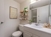 Thumbnail 51 of 51 - A bathroom with a toilet, sink, and mirror.