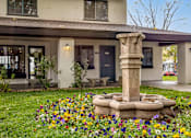 Thumbnail 30 of 51 - a garden with a stone fountain in front of a house