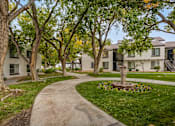 Thumbnail 4 of 51 - a sidewalk with trees and apartments in the background
