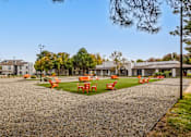 Thumbnail 35 of 51 - a park with orange tables and chairs on the grass