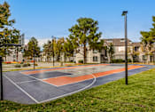 Thumbnail 1 of 51 - a basketball court with trees and apartments in the background