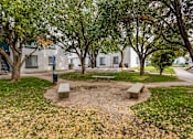 Thumbnail 34 of 51 - a park with benches and trees in front of a building