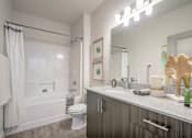 Thumbnail 10 of 34 - model bathroom with soaking tub and grey cabinetry