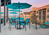 Thumbnail 17 of 34 - a patio with umbrellas and tables and chairs on a balcony