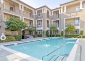 Thumbnail 15 of 21 - A swimming pool in front of apartment buildings.