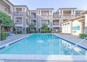 Thumbnail 14 of 21 - A swimming pool in front of apartment buildings.