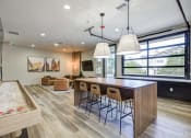 Thumbnail 9 of 38 - a kitchen and living room with a wooden table and chairs