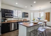 Thumbnail 1 of 38 - a kitchen with a large island and stainless steel appliances