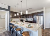 Thumbnail 6 of 26 - A kitchen with a large island and bar stools.
