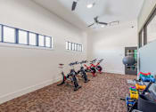 Thumbnail 12 of 26 - A room with exercise equipment and a ceiling fan.