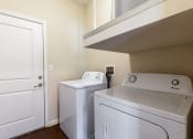 Thumbnail 31 of 31 - a laundry room with a washer and dryer and a door to a closet