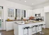 Thumbnail 5 of 18 - A modern kitchen with white cabinets and a central island.at The Yarra, Tennessee