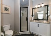 Thumbnail 21 of 33 - a bathroom with a walk in shower next to a toilet and a sink at Westmount at Ashwood, Atlanta, Georgia