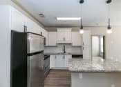 Thumbnail 16 of 33 - a kitchen with white cabinets and a granite counter top at Westmount at Ashwood, Atlanta