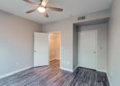 Thumbnail 8 of 27 - a bedroom with a ceiling fan and mirrored closets