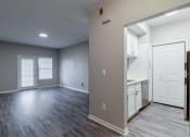 Thumbnail 5 of 27 - an empty living room and kitchen with white doors
