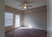 Thumbnail 7 of 27 - an empty living room with a ceiling fan and window