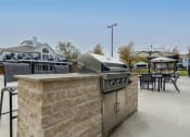 Thumbnail 21 of 27 - a patio with a grill and tables with chairs and umbrellas