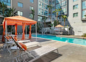 Thumbnail 2 of 32 - A pool area with sun loungers and a canopy.
