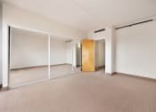 Thumbnail 16 of 27 - an empty room with mirrored doors and a door to a closet