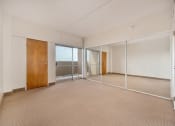 Thumbnail 17 of 27 - a living room with mirrored doors and a carpeted floor