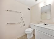 Thumbnail 14 of 27 - a bathroom with a toilet and a sink and a mirror