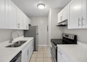 Thumbnail 23 of 31 - A kitchen with white cabinets and black appliances.