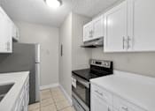 Thumbnail 22 of 31 - A kitchen with white cabinets and appliances.