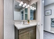Thumbnail 13 of 14 - A bathroom with a white sink and a mirror above it.