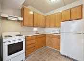 Thumbnail 13 of 27 - an empty kitchen with white appliances and wooden cabinets