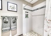 Thumbnail 14 of 14 - A bathroom with a white shower curtain and a white tiled shower wall.