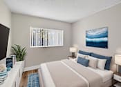 Thumbnail 19 of 31 - A bedroom with a large bed and a painting of a wave on the wall.