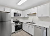 Thumbnail 15 of 15 - A kitchen with white cabinets and stainless steel appliances.